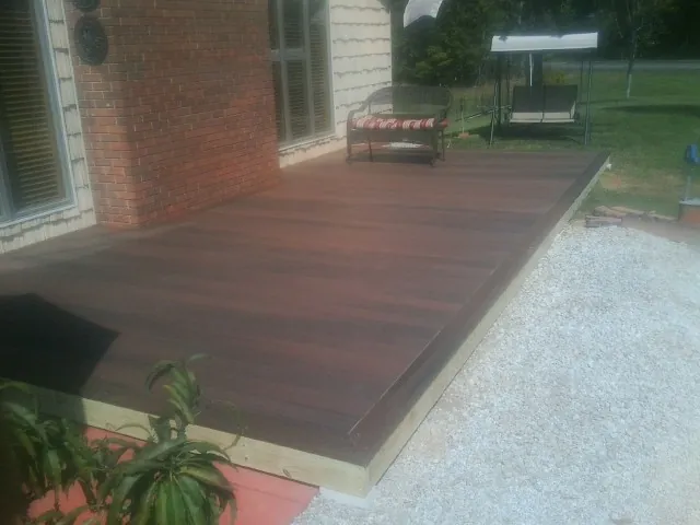 Freshly stained wood deck built against a brick home in Clay City